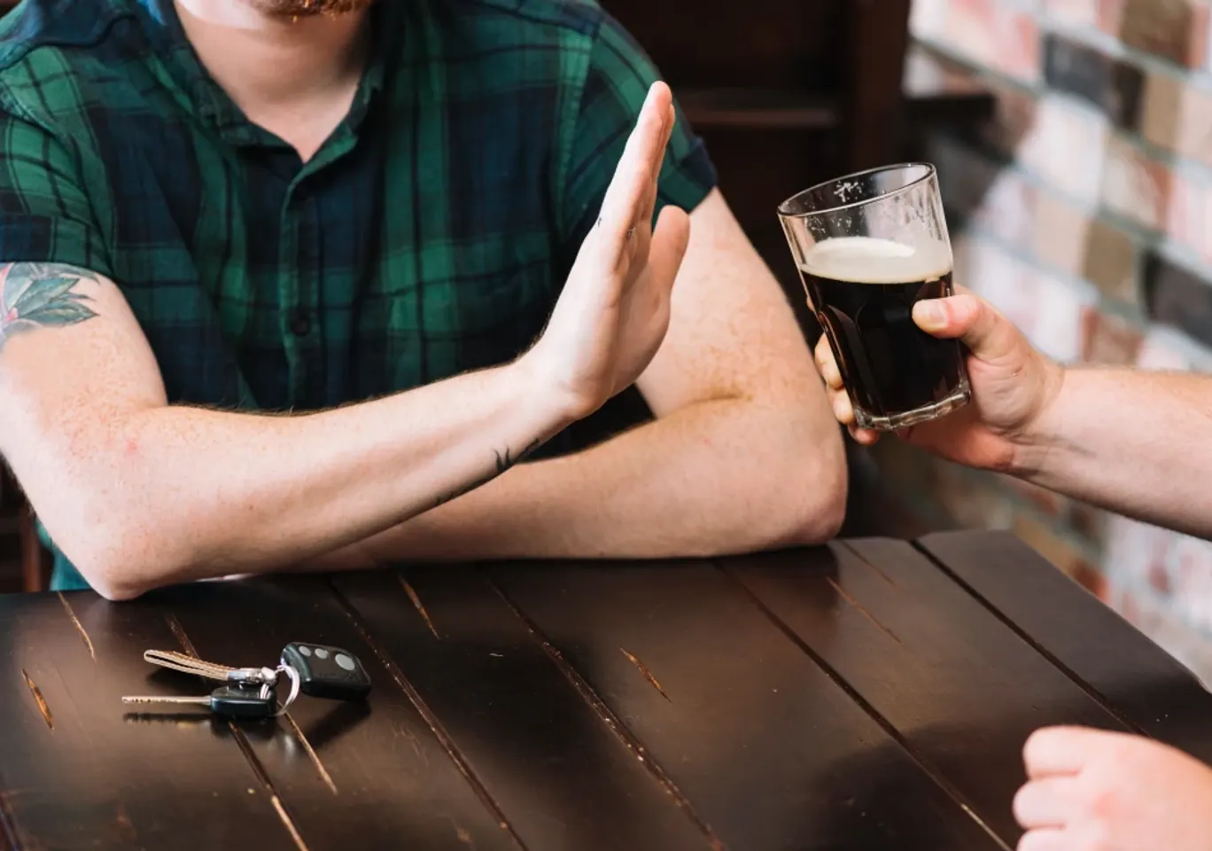 Wszywka alkoholowa Esperal / Disulfiram Zamość: dłoń odmawiająca kufla piwa przy stole
